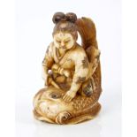 Late 19th century Japanese carved ivory netsuke of a girl slaying a large fish, signed, 5.