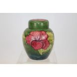 Moorcroft pottery Hibiscus pattern ginger jar with red flowers on green ground,