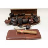 Collection of nine pipes, together with an oak pipe stand,