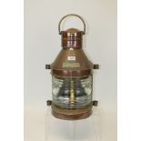 Large old copper masthead lamp of typical bowed form with titled plaque,