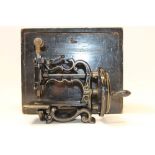 Late 19th / early 20th century miniature sewing machine with cast iron frame and floral decoration,
