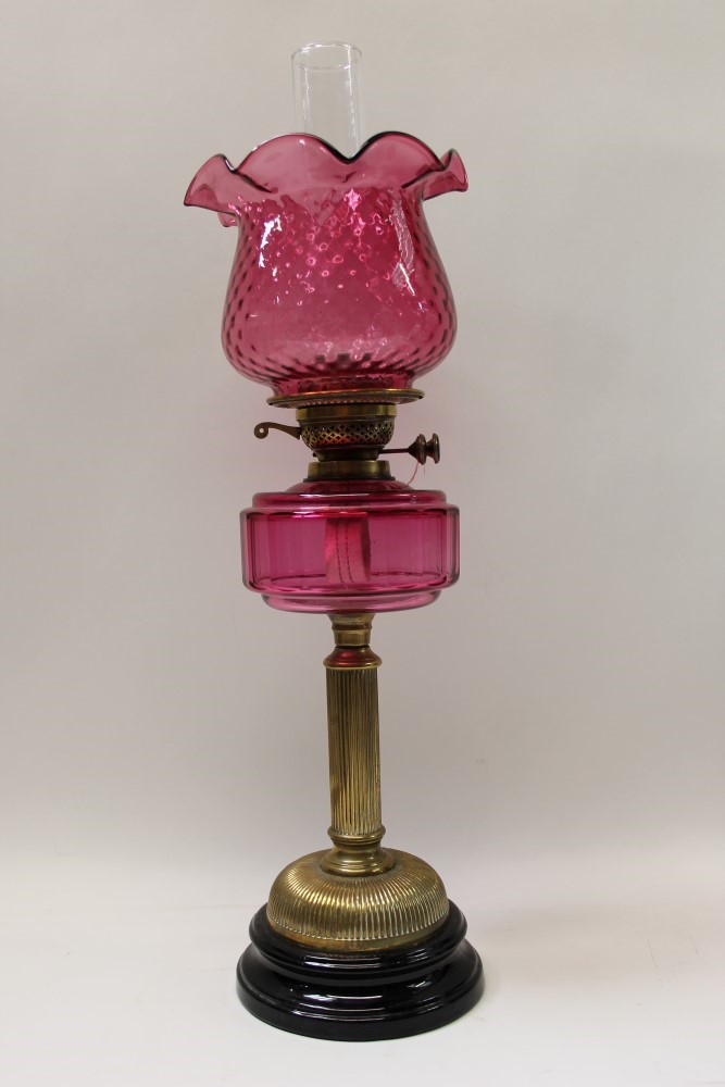 Victorian oil lamp with duplex burner, cranberry shade with flared border and clear glass chimney,