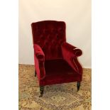 Good quality late Victorian armchair with red velvet buttoned upholstery on turned legs with brass