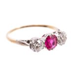 Ruby and diamond three stone ring with an oval mixed cut ruby flanked by an old cut diamond to each