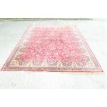 Tabriz-style carpet with all-over scattered foliage and red ground within foliate borders with