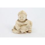 Early 20th century Japanese ivory netsuke modelled as a seated child holding a chicken,