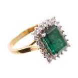 Emerald and diamond cluster ring with a large rectangular step cut emerald measuring 9.70mm x 6.