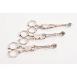 Three pairs of mid-18th century silver sugar nips with scissor-action, cast shell bowls,