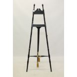 Victorian ebonised easel with adjustable peg supports and hinged A-frame with turned finials