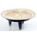 13th century Iranian Kashan lustre circular dish raised on three tapered legs painted with female