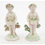 Two 18th century Derby putti holding floral baskets,