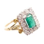 Emerald and diamond cluster ring, the rectangular step cut emerald measuring approximately 8.