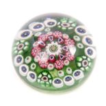 Antique glass paperweight with millefiori decoration on green ground,