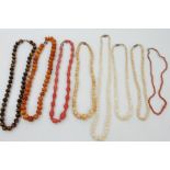 Amber necklace with rough tumbled butterscotch amber beads, two pink coral bead necklaces,