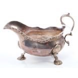 George III silver sauce boat of conventional form, with gadrooned border and scroll handle,