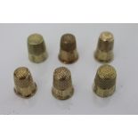 Six similar antique yellow metal thimbles, each with faceted sides, engraved acanthus panels,