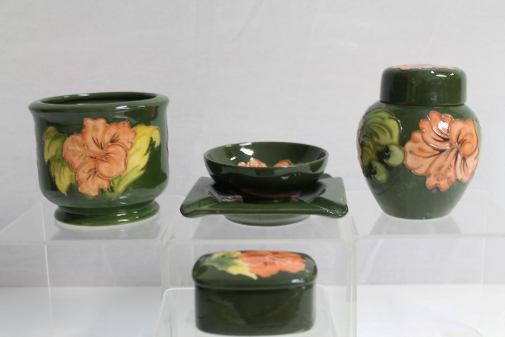 Selection of Moorcroft pottery Hibiscus pattern items on green ground - including small jar and