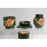 Selection of Moorcroft pottery Hibiscus pattern items on green ground - including small jar and