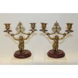 Pair of gilt metal two-branch candlesticks in the form of kneeling native woman holding entwined