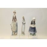 Three Lladro porcelain figures - elegant lady with parasol and dog,