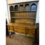 A 5' 1920's oak dresser with moulded cornice, arched detailing and beaded moulding to the two