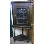 A 34" 19th Century oak corner cabinet on stand, with shelves enclosed by a leaded glazed panel door,