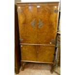 A 28 1/2" 20th Century walnut veneered drinks cabinet, with two pairs of cupboard doors and ornate