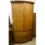 A 3' 4" Georgian style walnut bow front wardrobe with hanging space enclosed by a pair of cross