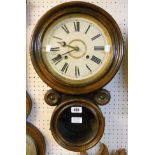 A late 19th Century stained wood wall clock, with circular glazed panel and visible pendulum -