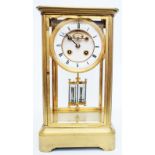 A gilt metal and bevelled four glass library clock with visible anchor escapement, twin mercury tube