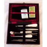 A leather needle case, including button hook, pen knife, silver thimble, etc. - sold with a