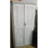 A 4' 9" painted pine corner cupboard with shelves enclosed by a pair of panelled doors, set on