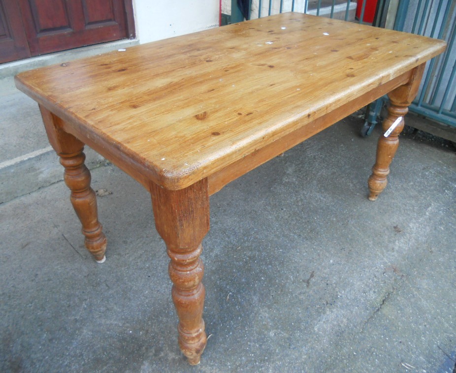 A 4' 5" stained pine kitchen table set on turned legs