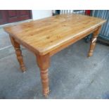 A 4' 5" stained pine kitchen table set on turned legs