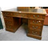 A 4' late Victorian stained oak twin pedestal desk with black leather inset top, three frieze