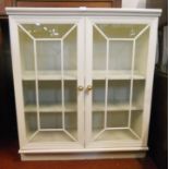 A 36 1/2" painted wood display cabinet with three shelves enclosed by a pair of astragal glazed