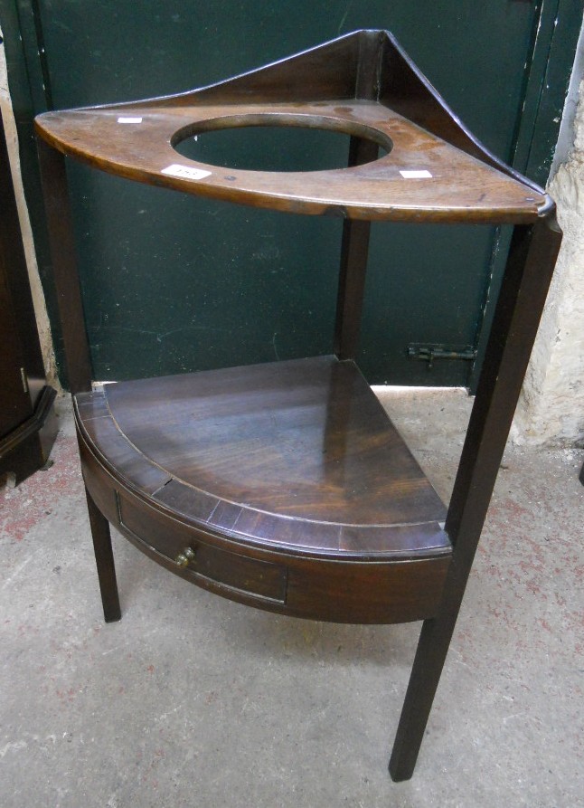 A late Georgian mahogany and strung corner washstand with bowl aperture, undertier and short drawer,