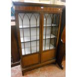 A 3' 1" 1920's mahogany display cabinet with paper lined shelves enclosed by a pair of part glazed