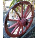 An antique red painted cartwheel