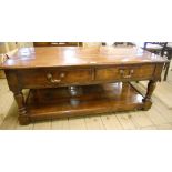 A 4' antiqued oak low table with two pairs of short opposing drawers, set on turned supports and