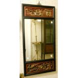 An Oriental black lacquer framed wall mirror with inset iron red and parcel gilt high relief