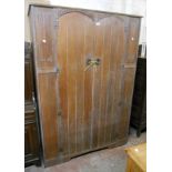 A 4' 1" Arts and Crafts style limed oak wardrobe with hanging space enclosed by a pair of doors with