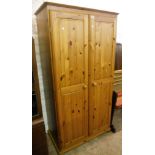 A 3' 2" modern polished pine two door wardrobe, set on bun feet