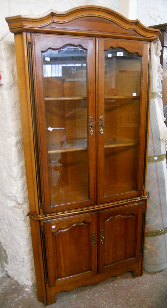 A 3' 1" polished stained wood two part corner cabinet by Pierre Fontaine, with moulded cornice and