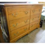 A modern polished pine chest with two flights of three short drawers, set on bracket feet