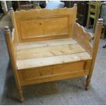 A 34" waxed pine child's bench/bed with panelled back, shaped sides and simple planked locker base