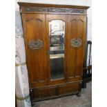 A 4' 1" early 20th Century oak wardrobe with mirrored door and moulded decoration with two short