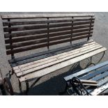 A 6' Victorian slatted garden bench on wrought iron scroll frame