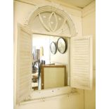 A painted wood framed decorative arched wall mirror with pair of shutter doors and flanking half