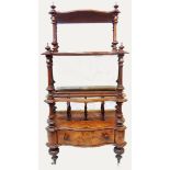 A Victorian figured walnut veneered what-not of serpentine design with cast brass rails, turned
